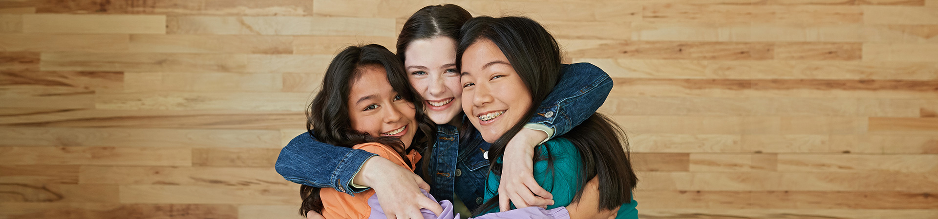  Photo of three girls hugging and smiling 